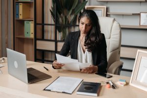 A woman sitting at a desk reading documents